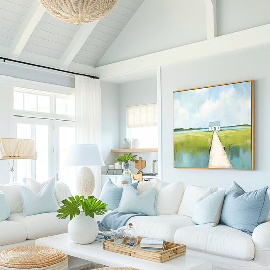 May include: A bright, airy living room with white sofas, light blue pillows, and a framed landscape painting. A woven light fixture hangs from the ceiling. The room has a coastal, relaxed vibe, with a white coffee table and decorative tray.